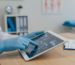 Hands on a digital tablet in a modern physical therapy office, symbolizing CPT code for physical therapy documentation.